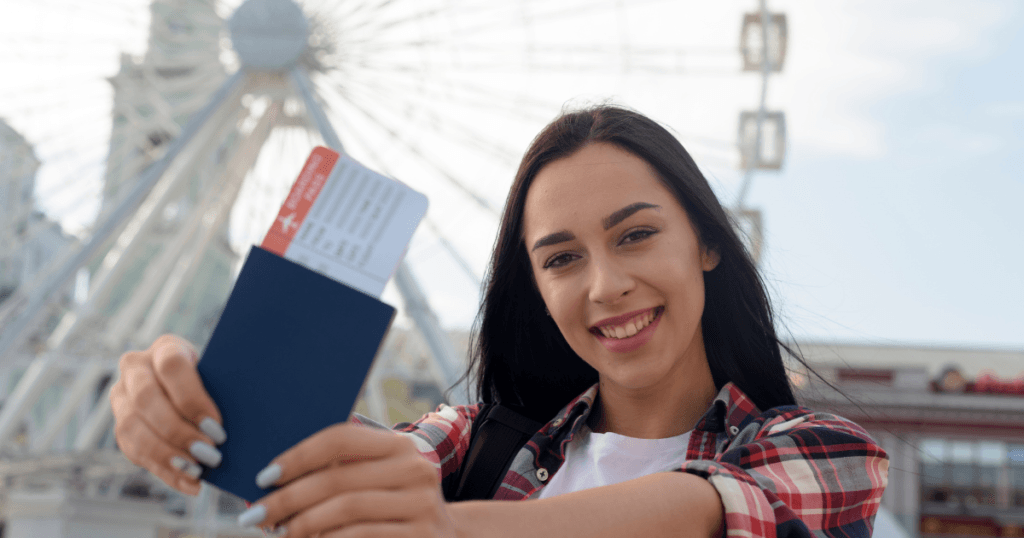 A student smiling and holding up her passport to represent statement of Purpose (SOP)