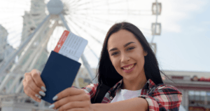 A student smiling and holding up her passport to represent statement of Purpose (SOP)