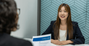 Two women in an office sitting for a Visa Interview