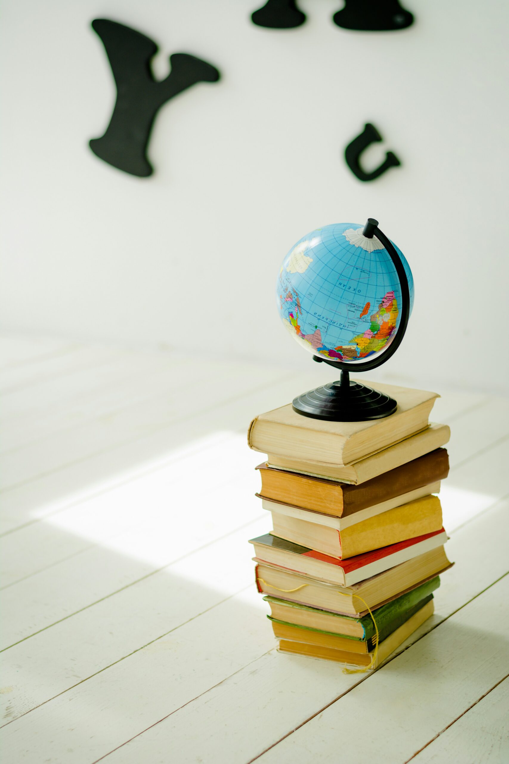 A pile of books with a globe on top