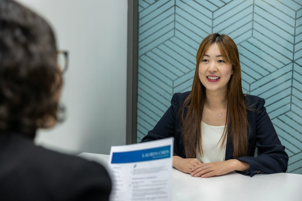 Two women in an office sitting for a Visa Interview