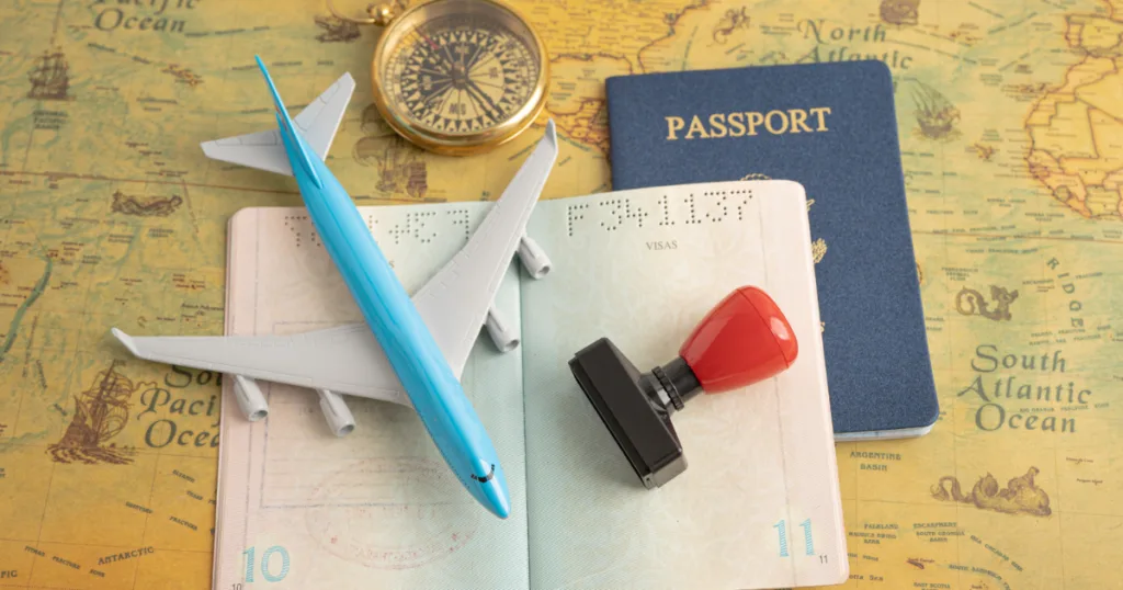 A minature plane, passport and stamp on the table to represent countries with the easiest student visa approval in 2026