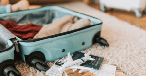 A luggage with minature plane, passport and other documents to represent What Documents Should International Students Carry in Their Hand Luggage?
